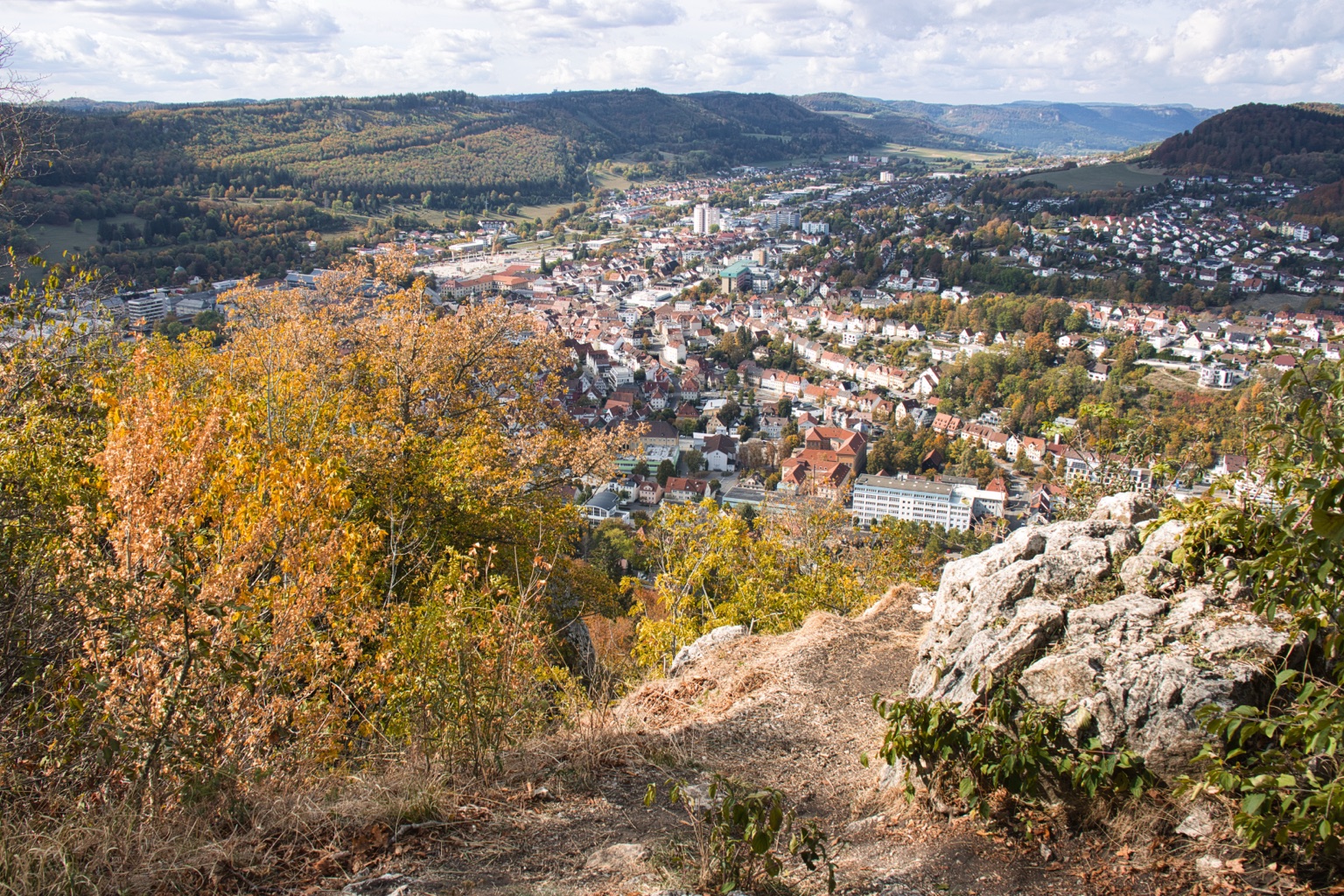 Weiter Blick über Ebingen mit goldenen Bäumen und hellen Felsen im Vordergrund
