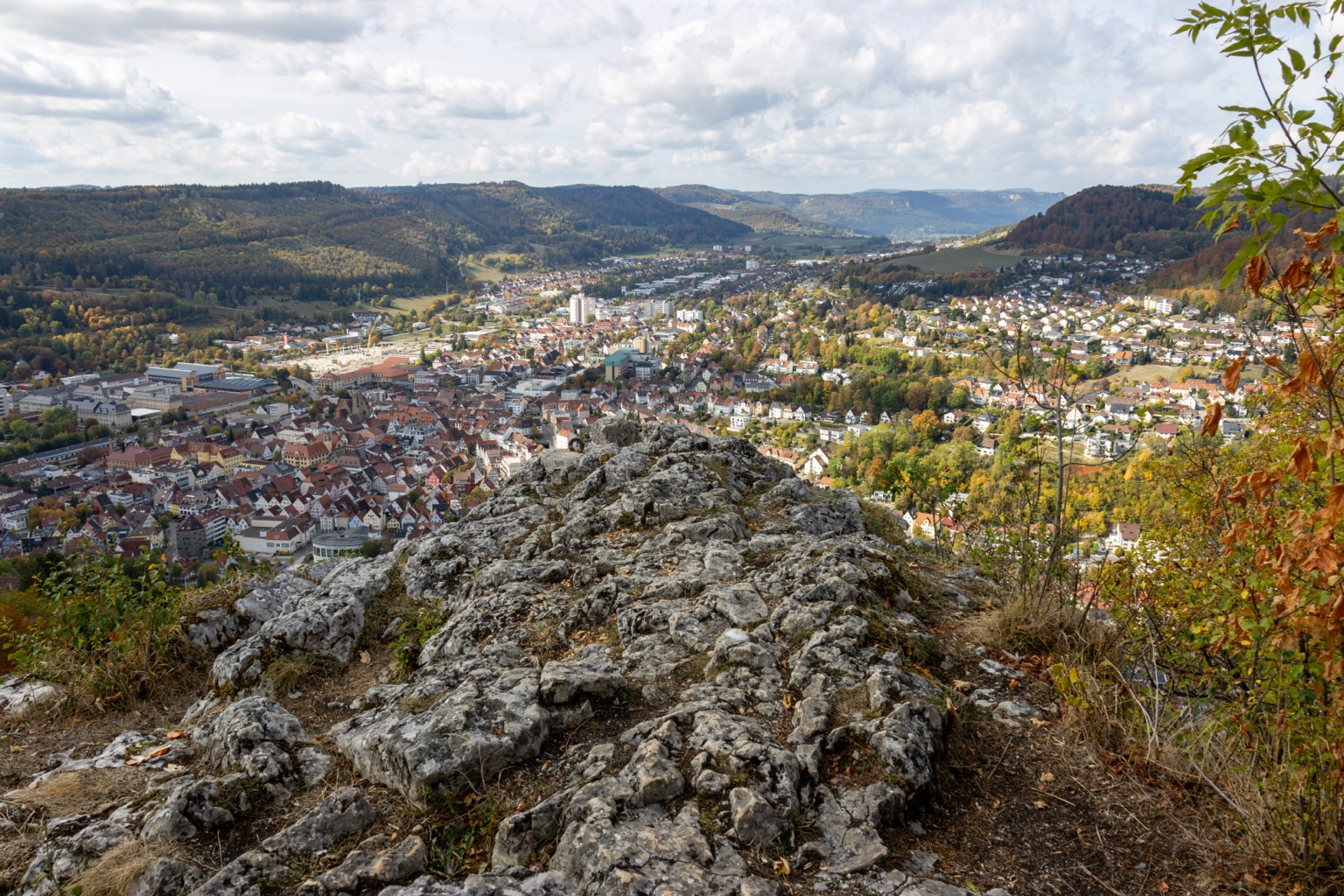 Raue graue Felsen vor einem weiten Blick auf Ebingen und die bewaldeten Hänge