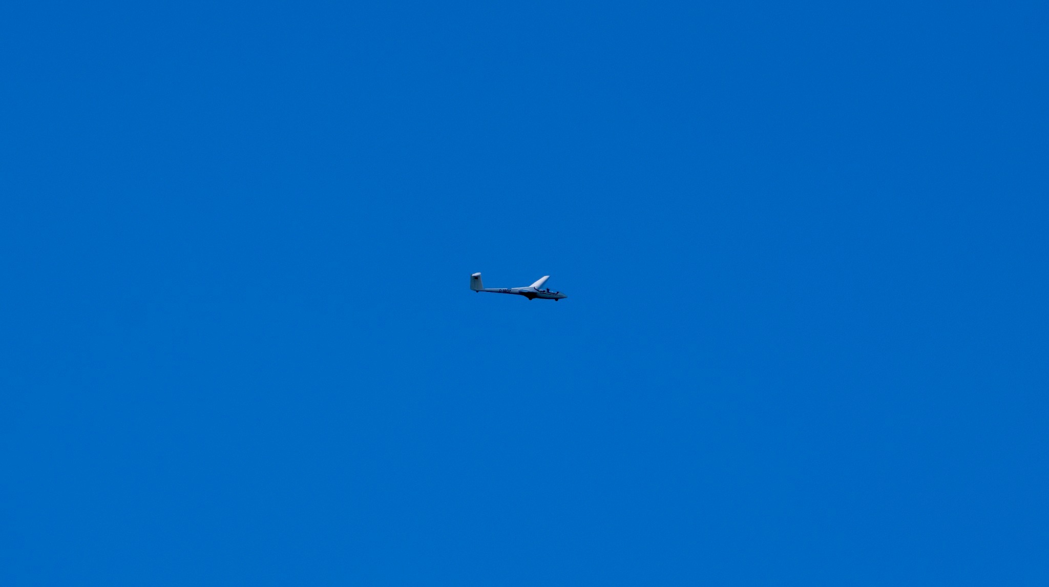 Entferntes Flugzeug am klaren blauen Himmel